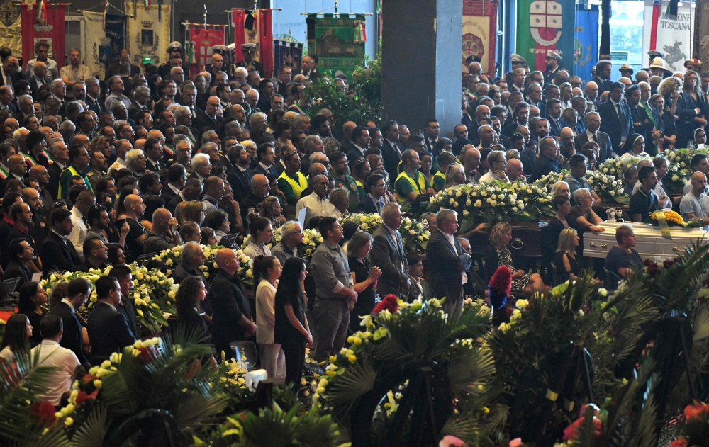 Relatives and citizens mourn and attend the mass of the state funeral for the victims of the Morandi Bridge collapse in Genoa, Italy, on Saturday. — AFP