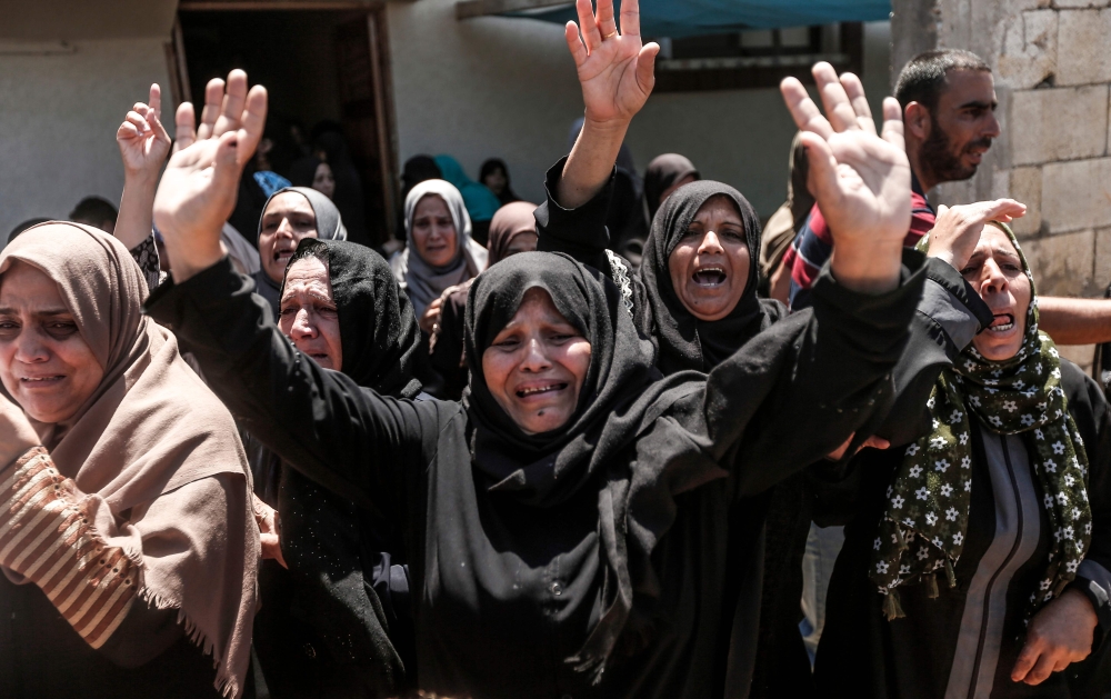 Relatives of Karim Abu Fatayer, a 30-year-old member of the Isl Hamas’ military wing Al-Qassam Brigades who was shot the day before while demonstrating near the border with Israel, mourn during his funeral in Deir Al-Balah in the central Gaza Strip on Saturday. — AFP