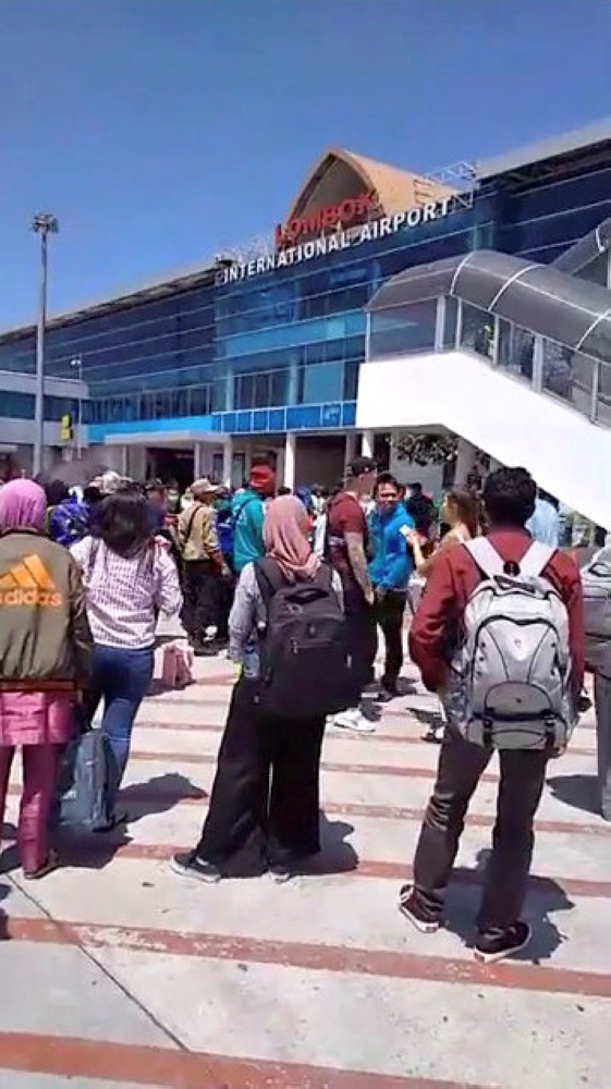 People evacuate from Lombok International Airport after an earthquake in this still image obtained from a social media video on Sunday. — Reuters