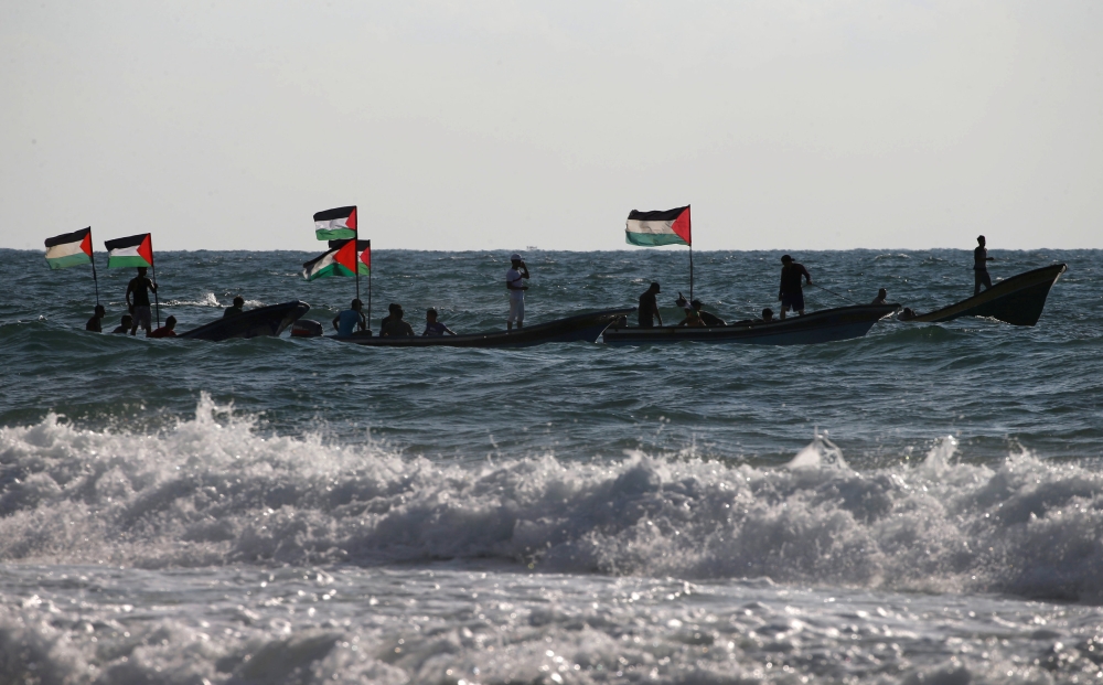 Palestinians ride boats during a protest against the Israeli blockade on Gaza at the sea in Gaza on Saturday. — Reuters