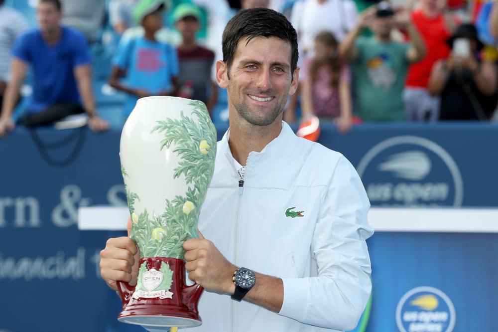 Novak Djokovic of Serbia poses with the winner's trophy after defeating Roger Federer of Switzerland at the Western & Southern Open at Lindner Family Tennis Center in Cincinnati Sunday. — AFP
