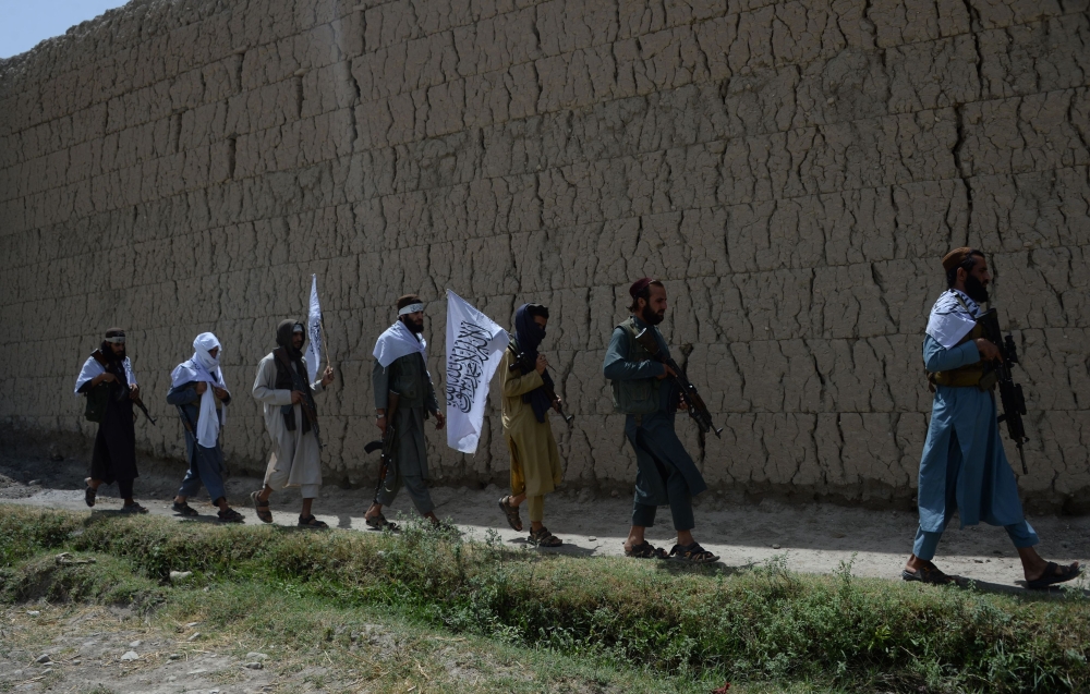 Afghan Taliban militants walk to celebrate an earlier ceasefire on the second day of Eid in the outskirts of Jalalabad in this June 16, 2018 file photo. — AFP