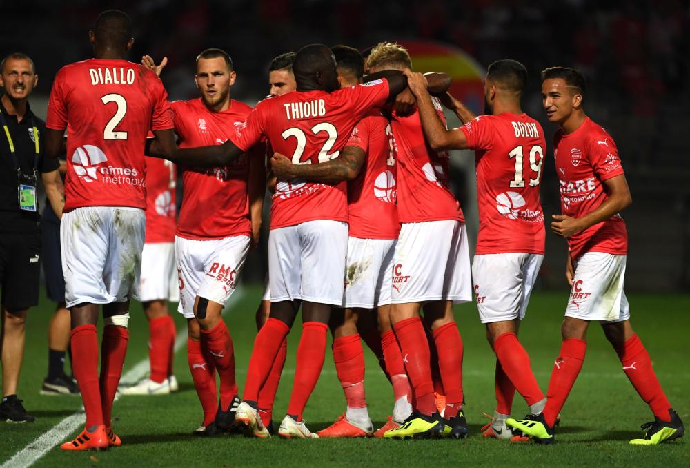 Nîmes's players celebrate a goal against Marseille during the French L1 at the Costières Stadium in Nîmes, southern France, Sunday. — AFP
