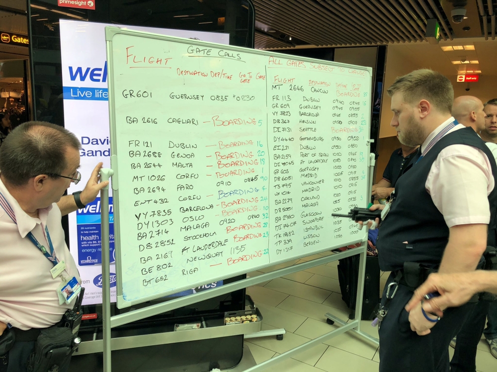Airport staff write on a white board as Gatwick, Britain’s second busiest airport, was forced to post flight information on white boards after an IT glitch meant its digital screens failed in Gatwick, London, on Monday in this picture obtained from social media. — Reuters