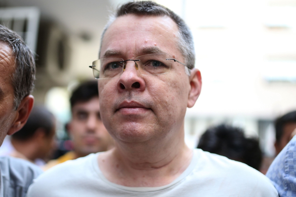 US pastor Andrew Craig Brunson is escorted by Turkish plain clothes police officers to his house in Izmir, Turkey, in this July 25, 2018 file photo. — AFP