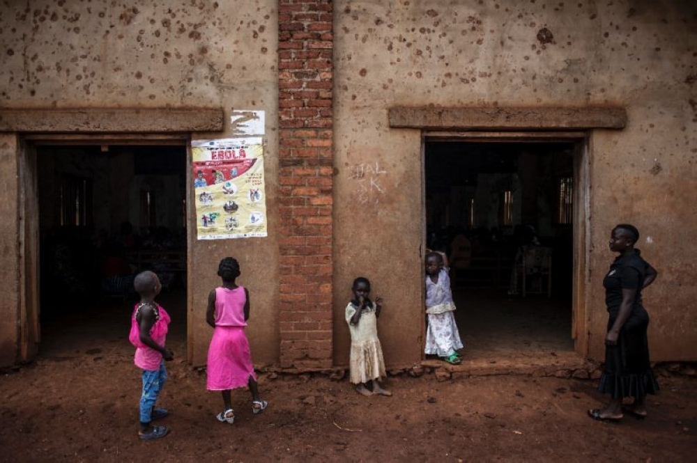 Children in DR Congo peruse a notice explaining the symptoms of Ebola in the town of Mangina after the tenth outbreak of the virus to afflict their country. — AFP