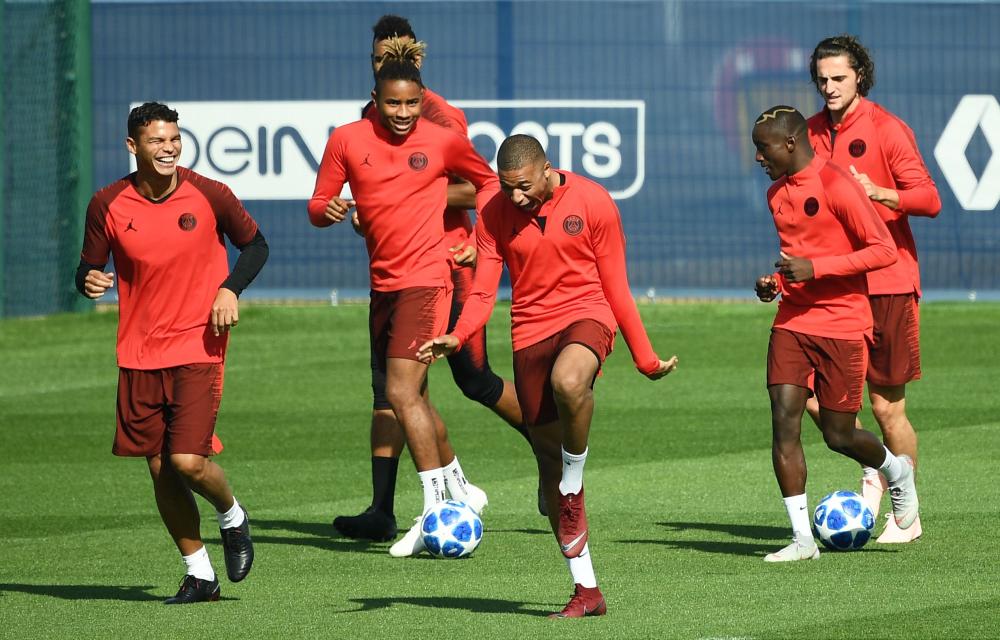 Paris Saint-Germain’s Thiago Silva (L) shares a laugh with Kylian MBappe (C) during a training session at Saint-Germain-en-Laye, western Paris, Monday. — AFP 