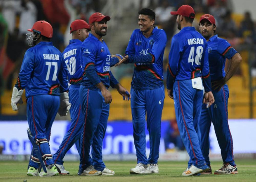 Afghan cricketer Mujeeb Ur Rahman (C) celebrates with his teammates after he dismissed Sri Lankan batsman Dasun Shanaka. — AFP