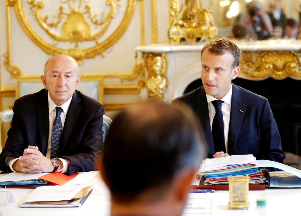 


French President Emmanuel Macron sits next to Interior Minister Gerard Collomb as he leads the last Cabinet meeting before the government goes on holidays at the Elysee Palace in Paris in this Aug. 3, 2018 file photo. — Reuters