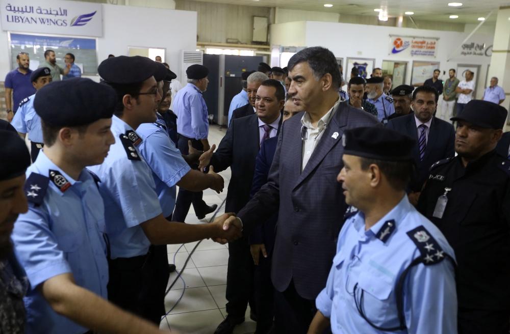 
Libyan Interior Minister Abdessalam Achour (C-R) and undersecretary of the Ministry of Communications in the Al-Wefaq Government Hisham Abu Shkiwat (C-L) greet members of the security forces after a press conference in which they unvailed new security dispositions for Tripoli’s Mitiga International Airport. — AFP
