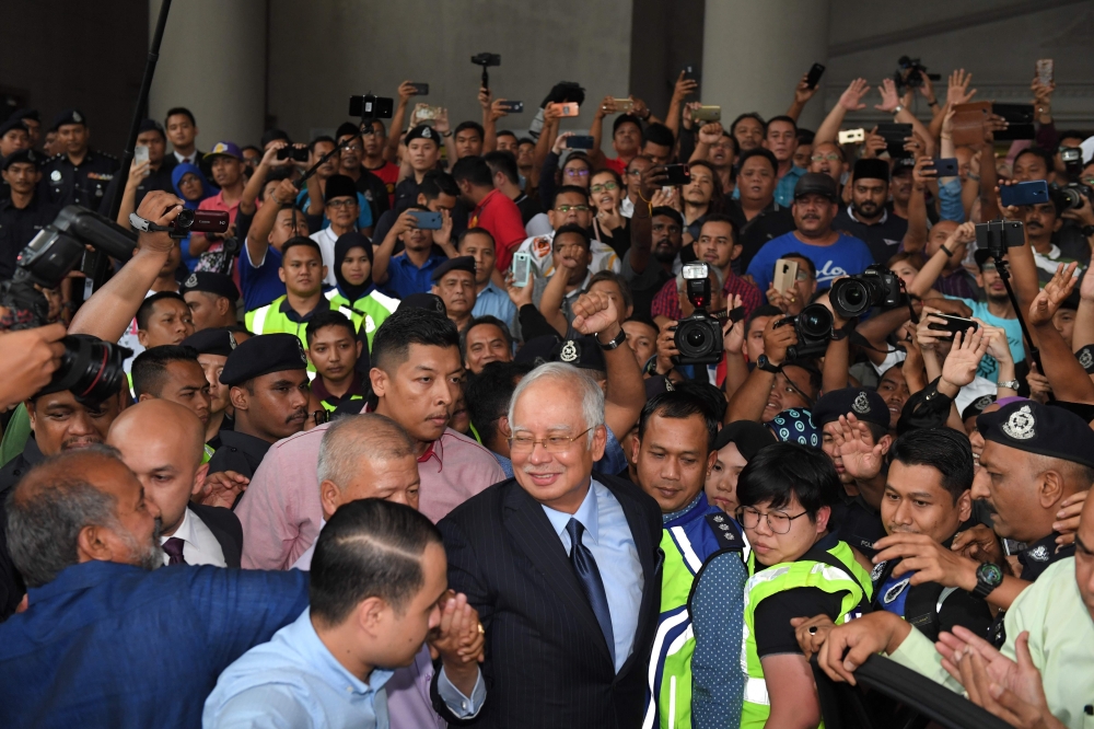 Former Malaysian Prime Minister Najib Razak greets supporters after a court appearance in Kuala Lumpur on Thursday. — AFP