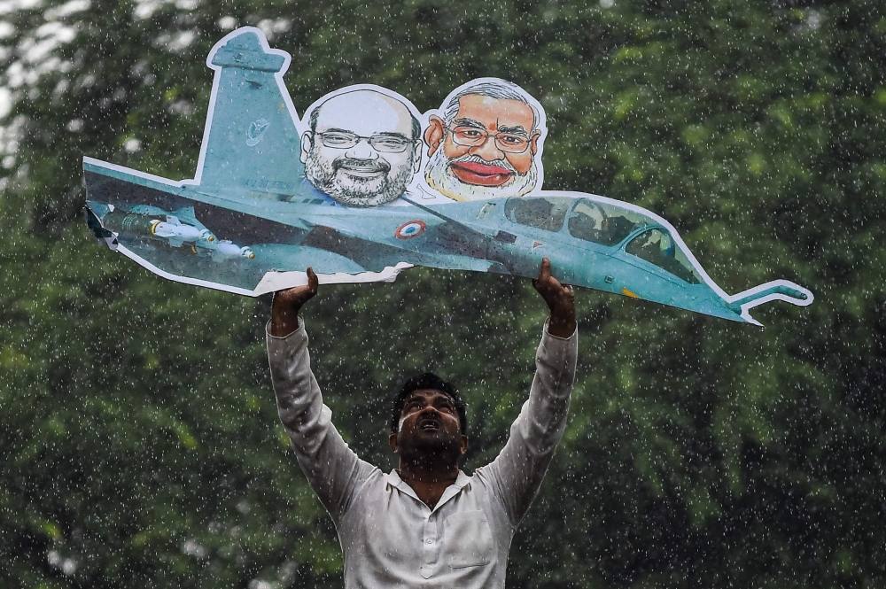 A supporter of the Indian Youth Congress holds a model of a Rafale fighter jet as he gets detained by police during a protest in New Delhi, Saturday. Former French president Francois Hollande has fueled controversy over India's multi-billion-dollar 2016 purchase of 36 Rafale fighter jets, saying that France was given no choice on the Indian partner for manufacturer Dassault. — AFP