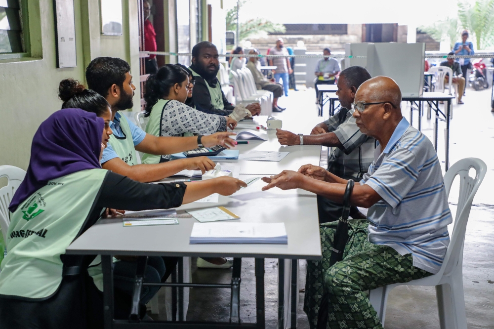 Maldives election workers are pictured at a polling station in the capital Male, Sunday. — AFP