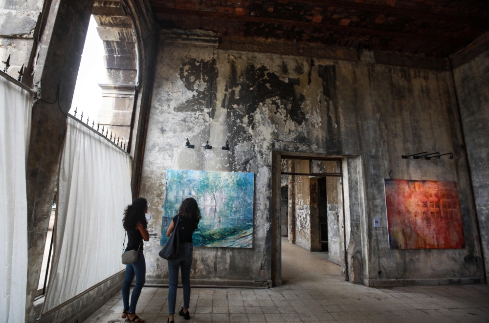 Visitors view paintings by 45-year-old British artist Tom Young during an exhibition at the Sofar Grand Hotel in the Lebanese village of Sofar, some 30 km east of Beirut, in this Sept. 21, 2018 file photo. — AFP