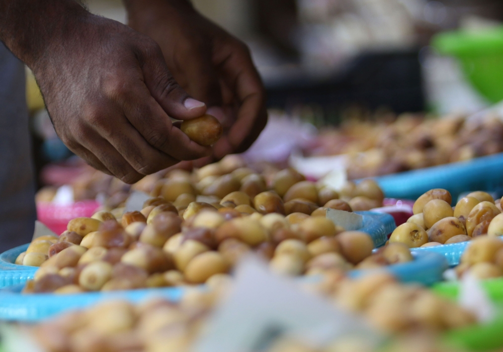 An Iraqi merchant wraps up a package of sweets at a shop selling dates and other date-related products in the region of Abu Al-Khasib, 25 km southeast of the southern city of Basra in this Aug. 31, 2018 file photo. — AFP