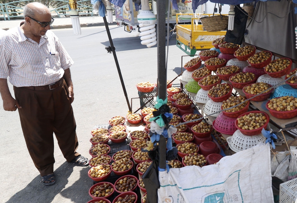 An Iraqi merchant wraps up a package of sweets at a shop selling dates and other date-related products in the region of Abu Al-Khasib, 25 km southeast of the southern city of Basra in this Aug. 31, 2018 file photo. — AFP