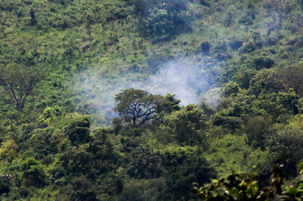 Smoke billows from trees after two Nigerian Air Force fighter jets taking part in rehearsals ahead of the nation’s Independence Day anniversary crashed on Katampe Hills, on the outskirts of Abuja, on Friday. — AFP