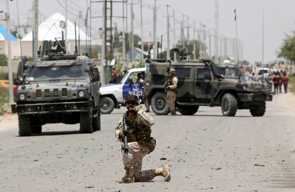 A soldier holds position as the damage is assessed after Al-Shabaab hit a European Union armored convoy in Mogadishu, Somalia, on Monday. — Reuters