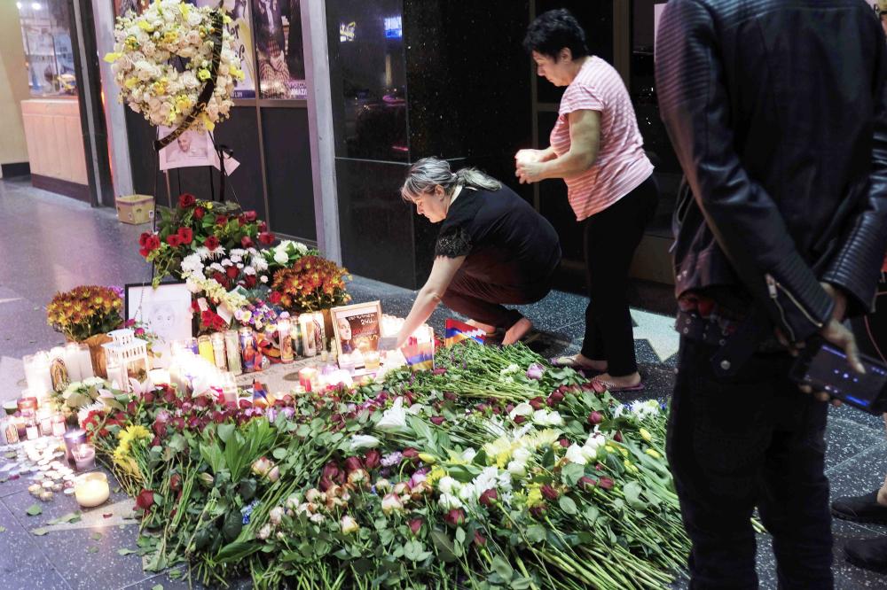


People pay homage to French-Armenian singer-songwriter Charles Aznavour as they lay flowers and candles on his Star on the Hollywood Walk of Fame in Hollywood, Los Angeles, 
on Tuesday. 