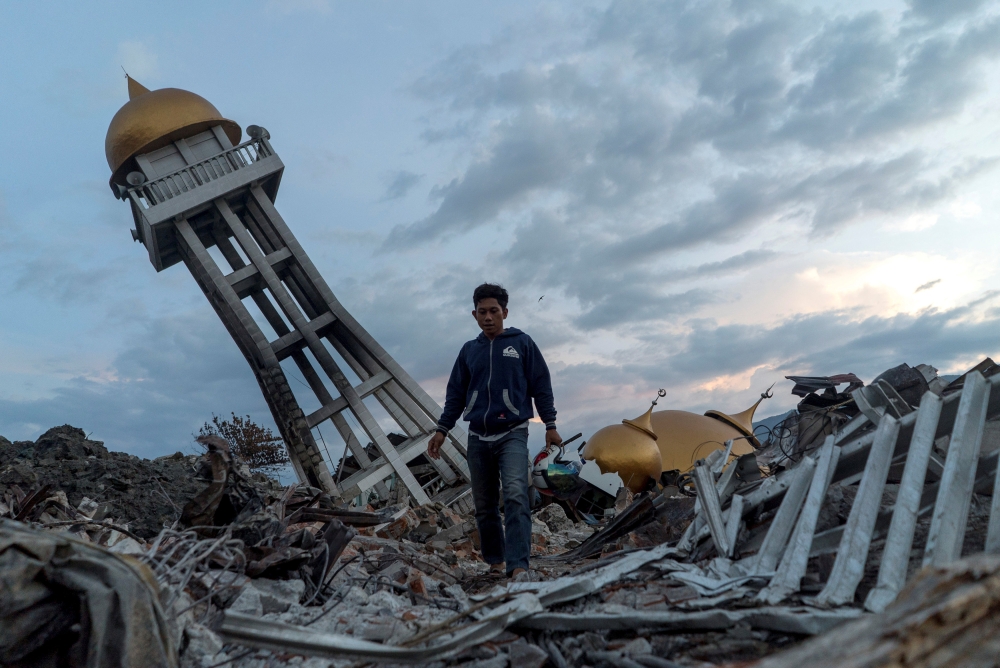 A resident walks at an area hit by the earthquake and tsunami in Palu, Central Sulawesi, Indonesia, on Thursday. — Reuters