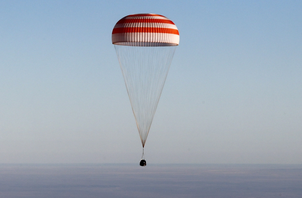 The Soyuz MS-08 capsule carrying the crew of Drew Feustel and Ricky Arnold of the US, and Oleg Artemyev of Russia, descends beneath a parachute just before landing in a remote area outside the town of Dzhezkazgan (Zhezkazgan), Kazakhstan, on Thursday. — Reuters