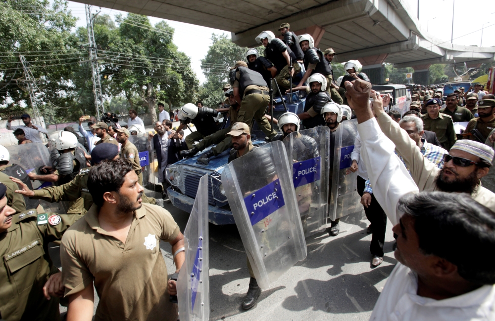 Supporters of Pakistani opposition leader Shehbaz Sharif chant slogans as police escort an armored personal carrier (APC) carrying him after he was ordered jailed by an anti-corruption court, in Lahore, Saturday. — Reuters