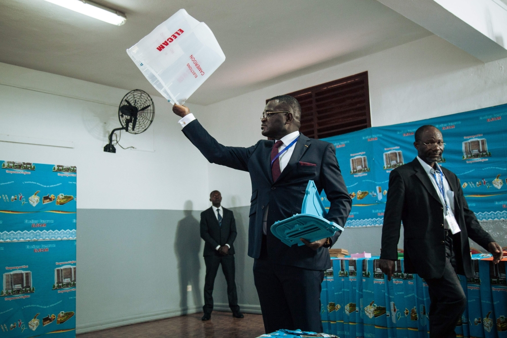 The president of the polling station where the incumbent president voted shows the poll to the observers, in Bastos neighborhood in the capital Yaounde, Sunday. — AFP