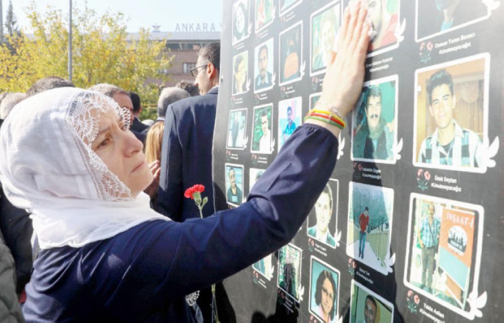 
A woman stands in front of photographs of suicide attack victims, during a demonstration in Ankara, on Wednesday, which was held to mark the third anniversary of twin suicide attacks on October 10, 2015 which took place in the Turkish capital. — AFP