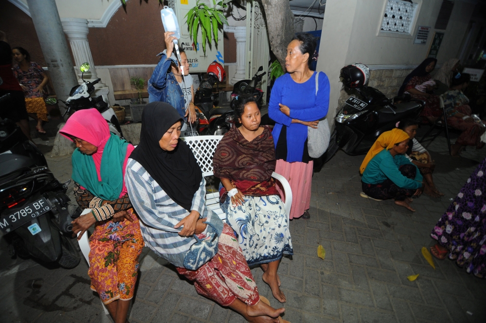 Patients sit at an open area after an earthquake, at Larasati hospital in Pamekasan, Indonesia, on Thursday. — Reuters