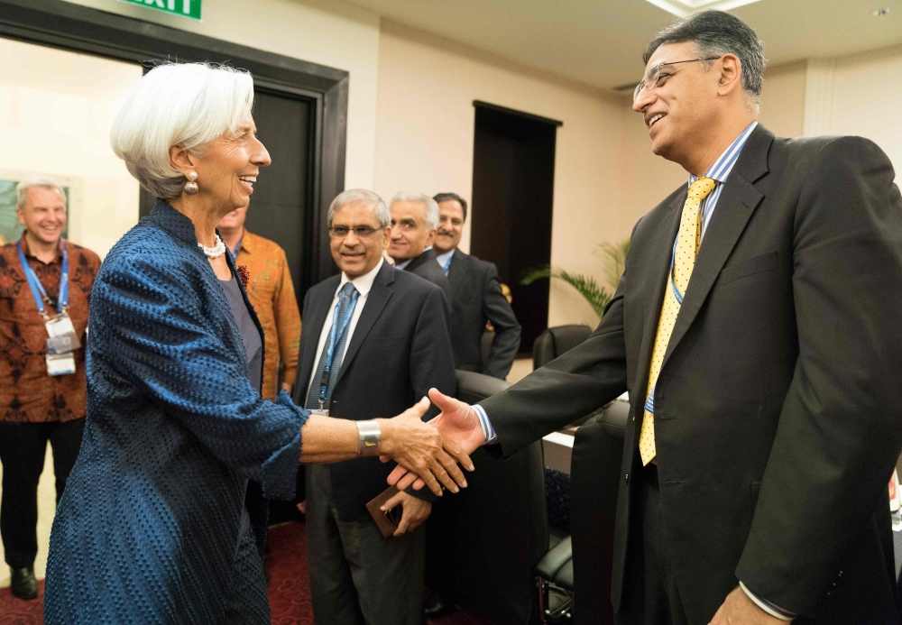 IMF Managing Director Christine Lagarde, left, greets Pakistan Finance Minister Asad Umar at the Bali Convention Centre during the 2018 IMF/World Bank annual meetings in Nusa Dua on the Indonesian resort island of Bali on Thursday. — AFP