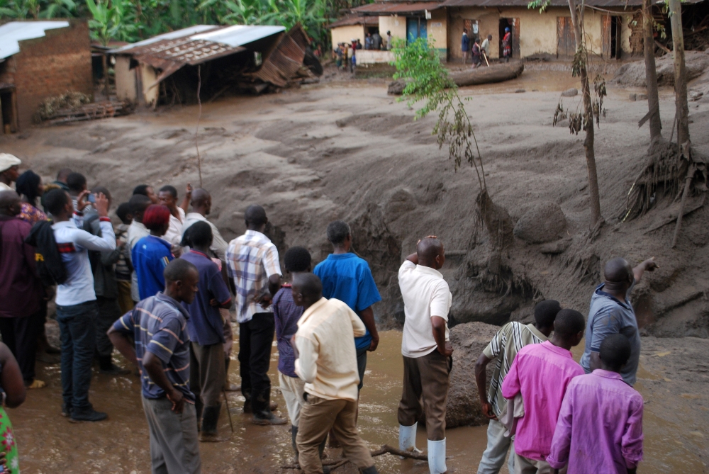 Survivors look at the aftermath as flood waters pass through destroyed homes, after a landslide rolled down the slopes of Mt. Elgon through their village in Bududa district, Uganda, on Friday. — Reuters