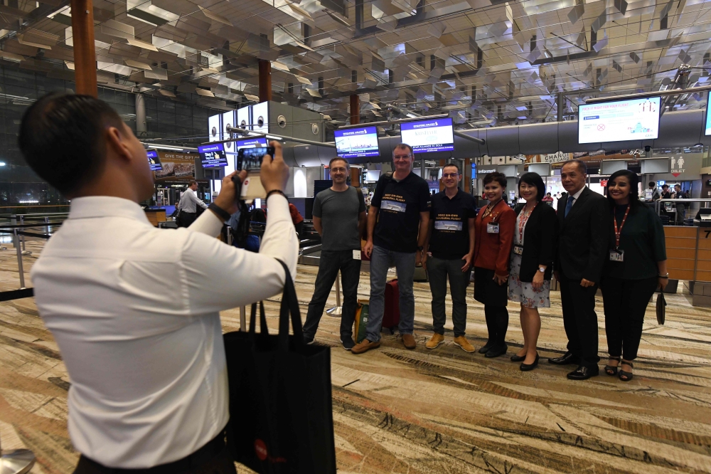 Pier Messaggio, fourth left, Italian electronics designer poses with other passengers of flight SQ22, Singapore Airlines’ inaugural non-stop flight to New York with airport staff after checking in at Changi International Airport in Singapore on Thursday. — AFP
