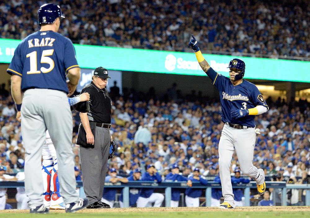 


Orlando Arcia (R) of the Milwaukee Brewers celebrates as he crosses home plate after hitting a two-run home run to right field while home plate umpire Gerry Davis and teammate Erik Kratz look on during the seventh inning of Game 3 of the National League Championship Series against the Los Angeles Dodgers at Dodger Stadium in Los Angeles Monday. — AFP 