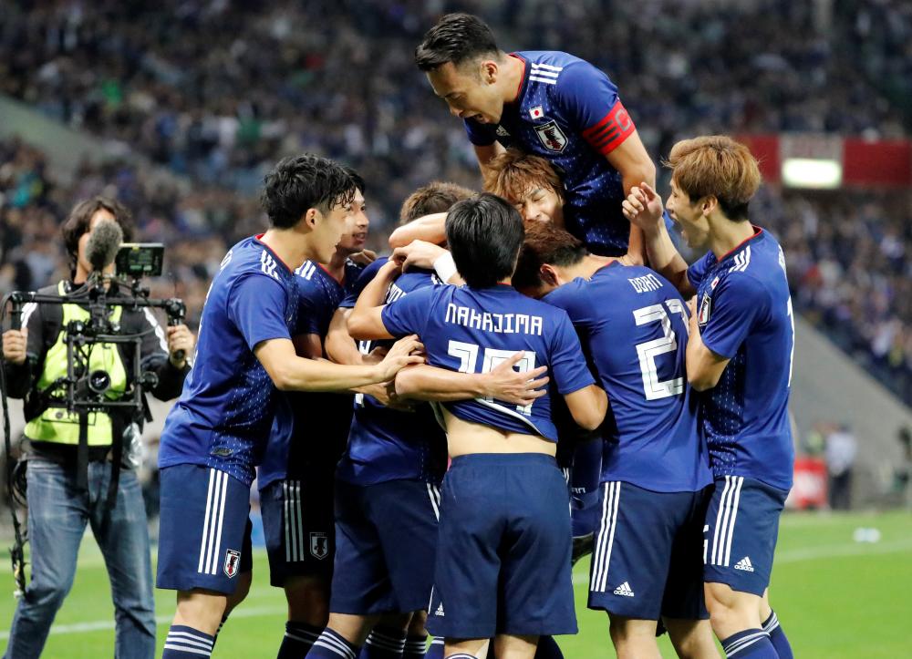 


Japan’s Takumi Minamino celebrates scoring their first goal with teammates against Uruguay during their friendly at Saitama Stadium Tuesday. — Reuters