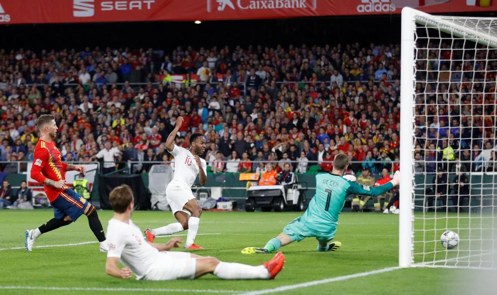 


England’s Raheem Sterling scores their third goal past Spain’s goalkeeper David De Gea during the UEFA Nations League Championship at Estadio Benito Villamarin in Seville Monday. — Reuters  