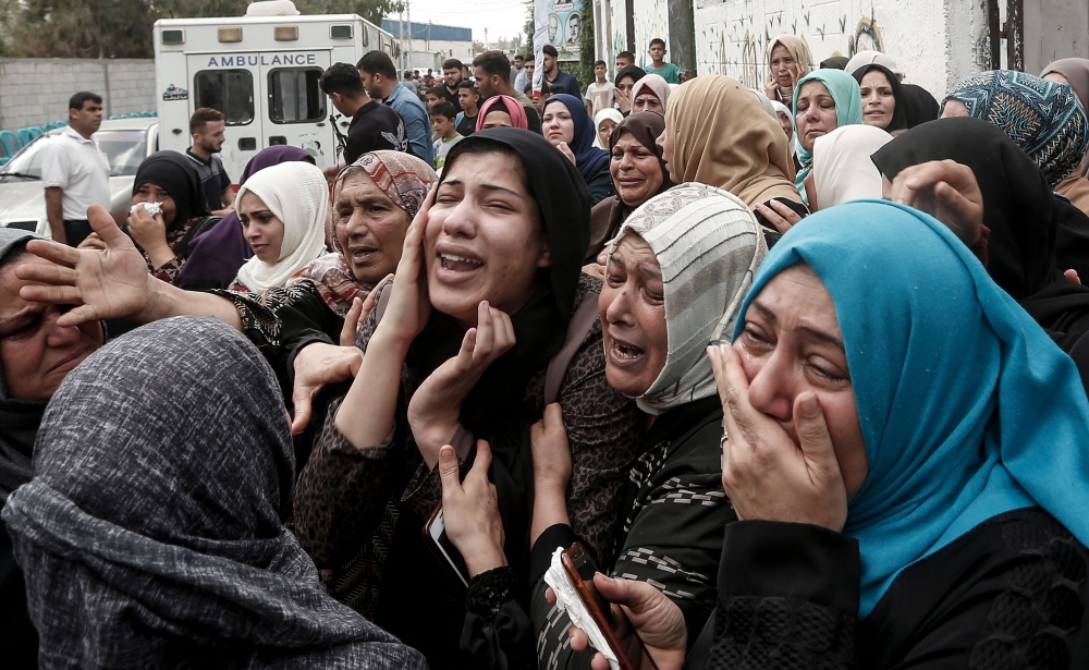 Relatives of Palestinian Naji Al-Za'aneen, 25, mourn during his funeral in the northern Gaza Strip, Wednesday. The Israeli army said Za'aneen was preparing a rocket launch when he was killed in a retaliatory airstrike. — AFP
