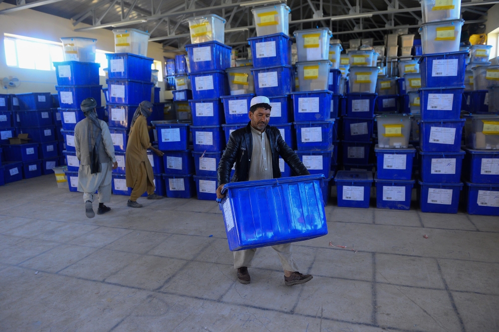 Afghan employees of the Independent Election Commission (IEC) carry ballot boxes at a warehouse in Herat province on Wednesday. — AFP