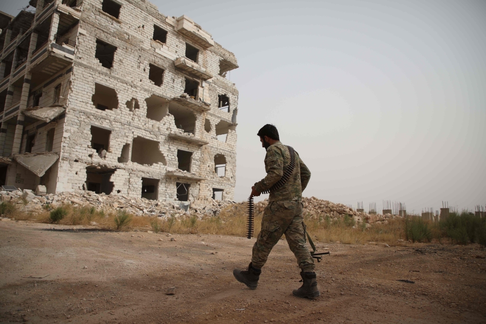 A Syrian rebel-fighter from the National Liberation Front (NLF) walks in a street in the rebel-held Al-Rashidin district of western Aleppo’s countryside near Idlib province, in this Oct. 15, 2018 file photo. — AFP