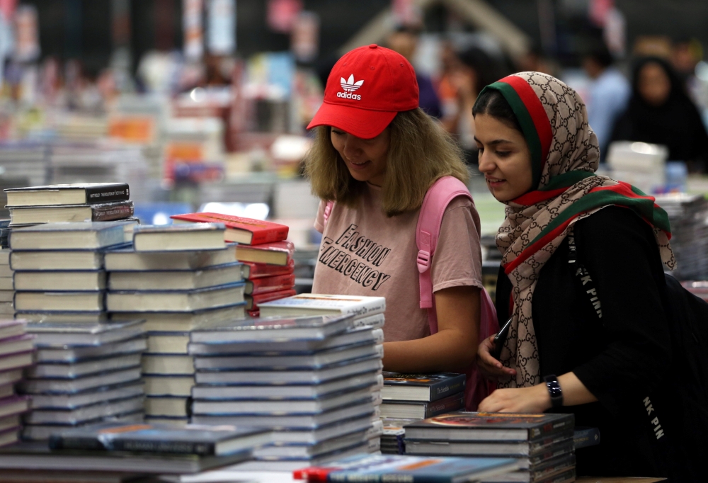 Visitors read books at the Big Bad Wolf Book Sale, which calls itself the world’s biggest, hosted for the first time by Dubai, on Wednesday. — Reuters