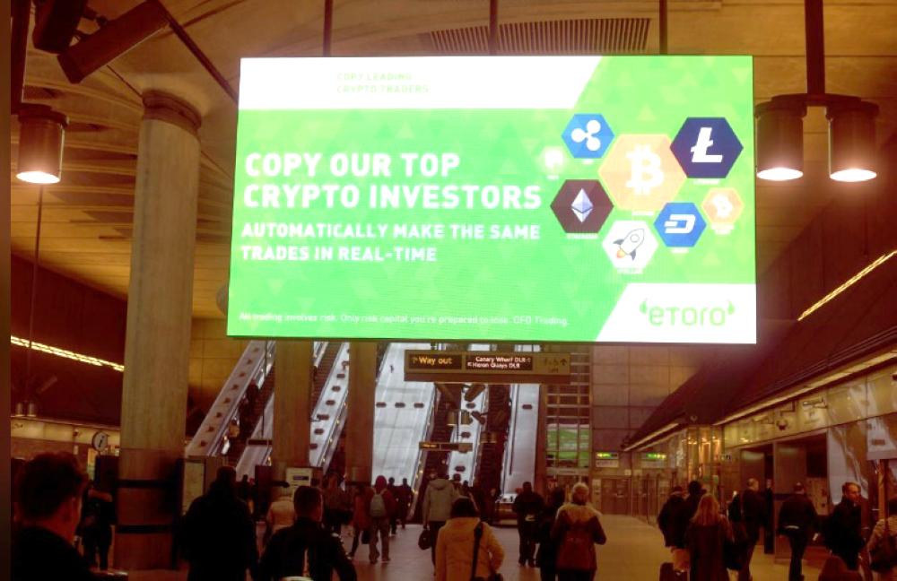 Giant electronic billboards display adverts for crypto currency investment companies as commuters arrive at Canary Wharf tube station in London, Britain, in this file photo. — Reuters