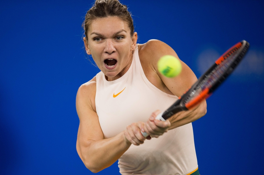 In this file photo Simona Halep of Romania hits a return against Dominika Cibulkova of Slovakia during their women's singles third round match of the WTA Wuhan Open tennis tournament in Wuhan. World No. 1 Halep on Thursday withdrew from the WTA Finals in Singapore due to a back injury, the latest tournament she has been forced to abandon. — AFP