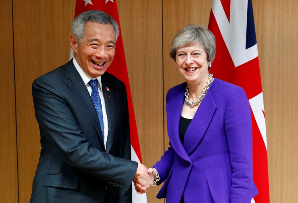 Singapore's Prime Minister Lee Hsien Loong poses with Britain's counterpart Theresa May at the ASEM leaders summit in Brussels, Belgium on Thursday. — Reuters