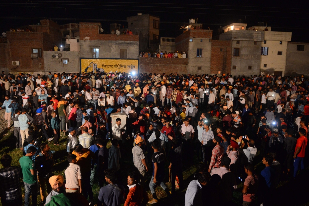 Indian relatives and revelers gather around the bodies of the victims of a train accident during the occasion of the Hindu festival of Dussehra in Amritsar, Punjab, on Friday. — AFP