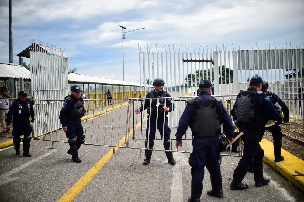Mexican Federal Police officers get ready for the arrival of a caravan of Honduran migrants heading to the US, on the international bridge in Ciudad Hidalgo, Chiapas state, Mexico, in the border with Guatemala, on Friday. — AFP