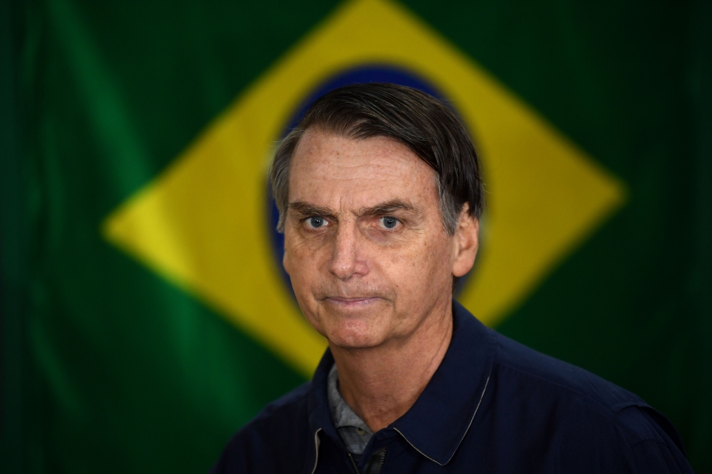 Brazil’s right-wing presidential candidate for the Social Liberal Party (PSL) Jair Bolsonaro walks in front of the Brazilian flag as he prepares to cast his vote during the general elections, in Rio de Janeiro, Brazil, in this Oct. 7, 2018 file photo. — AFP