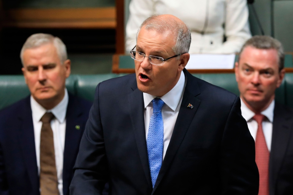 Australian Prime Minister Scott Morrison, center, delivers a national apology to child sex abuse victims in the House of Representatives in Parliament House in Canberra on Monday. — AFP