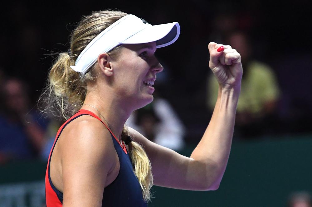 Denmark’s Caroline Wozniacki celebrates after defeating Czech Republic’s Petra Kvitova at the WTA Finals Tennis Tournament in Singapore Tuesday. — AFP 