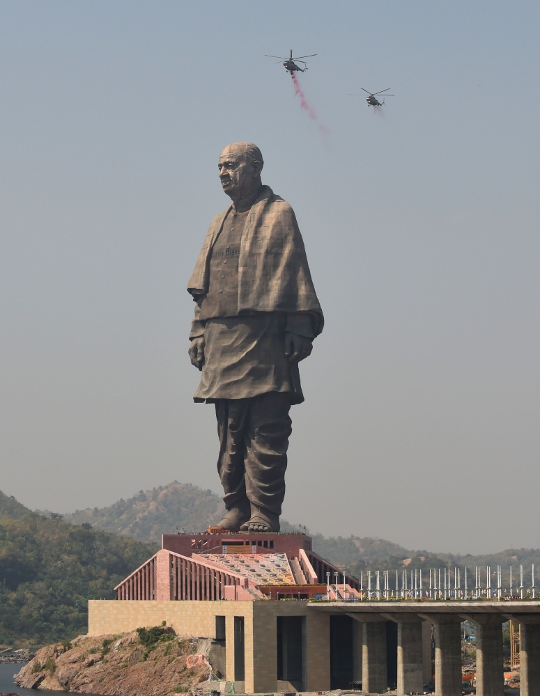 Indian Air Force helicopters shower rose petals on the ‘Statue Of Unity’, the world’s tallest statue dedicated to Indian independence leader Sardar Vallabhbhai Patel, overlooking the Sardar Sarovar Dam near Vadodara in India’s western Gujarat state on Wednesday. — AFP