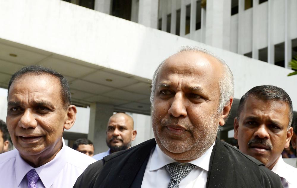 


Leader of the Sri Lanka Muslim Congress Rauff Hakeem, second right, walks out from the Supreme Court after filing a petition against President Maithripala Sirisena’s sacking of the legislature, in Colombo, on Monday. — AFP