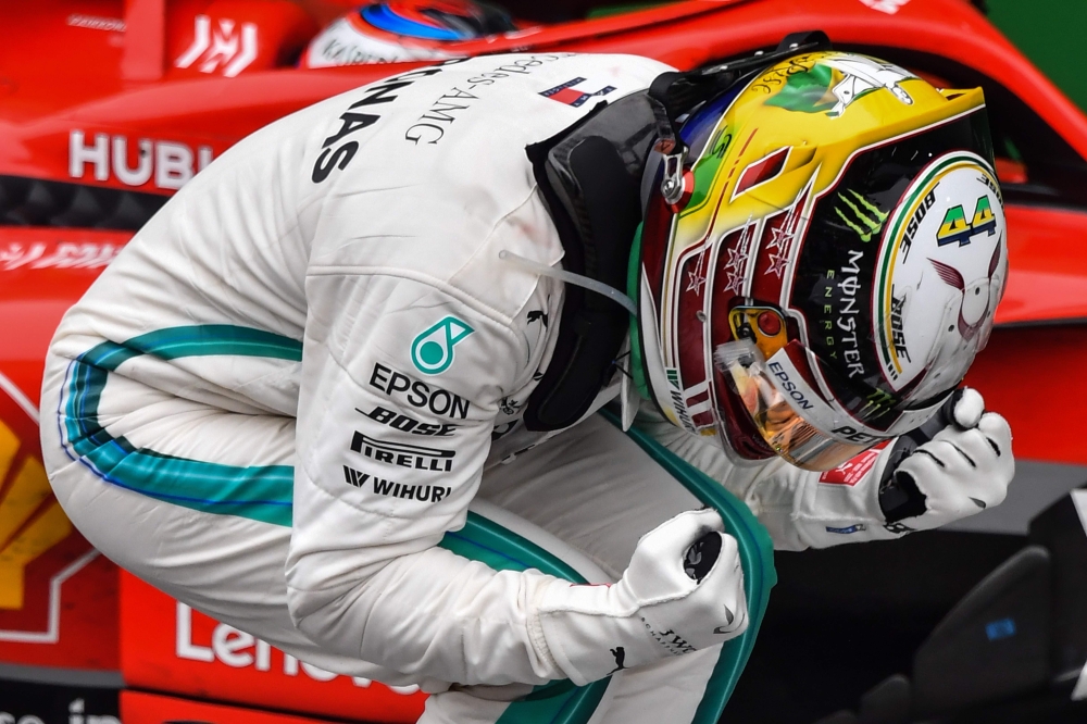 Mercedes' British driver Lewis Hamilton celebrates after winning the F1 Brazil Grand Prix, while Mercedes took the constructors title, at the Interlagos racetrack in Sao Paulo, Brazil on Sunday. Max Verstappen in a Red Bull was second with Ferrari's Kimi Raikkonen in third. — AFP